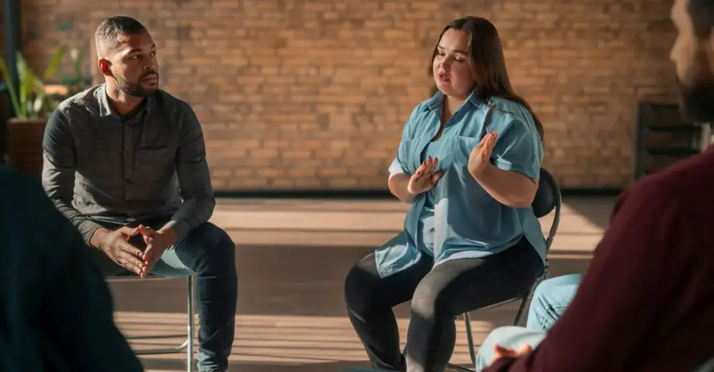 People participating in group therapy session for alcohol addiction recovery in a rehab center