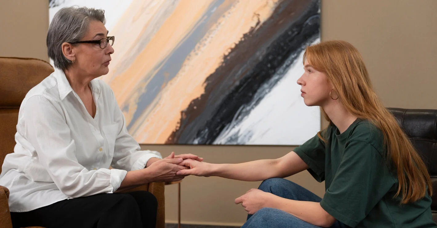 Therapist providing emotional support to a young woman during a mental health counselling session