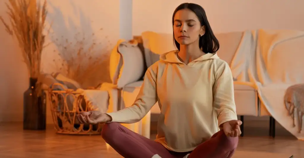 Woman practicing meditation for stress relief and mental wellness in a calm home environment