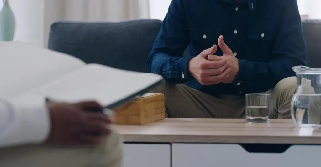 Man speaking with a psychologist during a therapy session for addiction recovery in Dubai